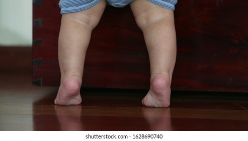 
Baby Little Feet On Tip Toes. Toddler Reaching And Standing Up