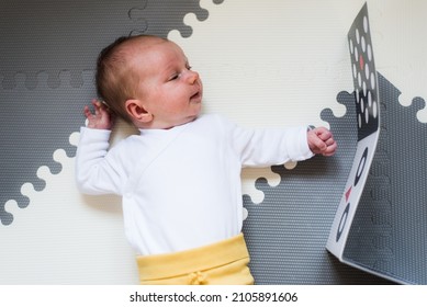 baby looking at black and white contrast book - Shutterstock ID 2105891606