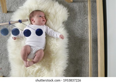 Baby Looking In Mirror With Montessori Mobile Overhead