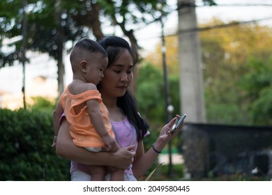 Baby Looking At Mobile Phone With Mom