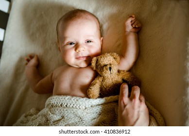 Baby Lying On Bed At Home. Mom Putting A Blanket On Her Baby.