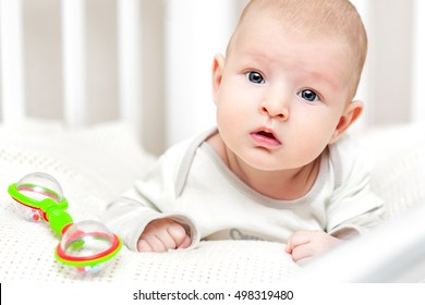 Baby Lying On His Stomach With A Rattle