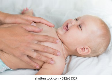 Baby Massage. Mother Massaging Infant Belly, Kid Laughing