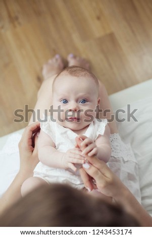 Baby and mom are at home. The mother holds her little child. Newborn. Baby's feet in the mother hands. Cozy. Love.