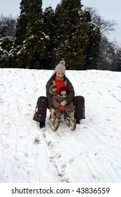 Baby And Mom Sledding In Cold Winter Day