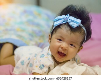 A Baby In Moment Turn Up Side Down On Bed 4 Month Old, Baby Development And Learning Concept ,Soft Focus Background