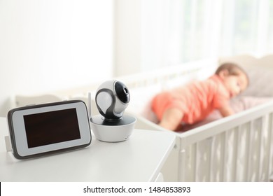 Baby Monitor And Camera On Table Near Crib With Child In Room. Video Nanny