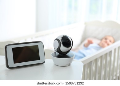 Baby Monitor And Camera On Table Near Crib With Child In Room. Video Nanny