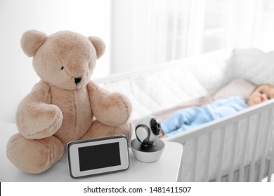 Baby Monitor, Camera And Toy On Table Near Crib With Child In Room. Video Nanny