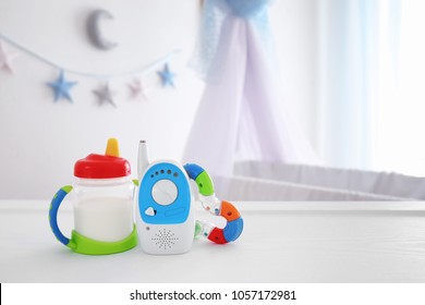 Baby Monitor, Rattle And Sippy Cup On Table In Room. Radio Nanny