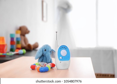 Baby Monitor, Rattle And Toy On Table In Room. Radio Nanny