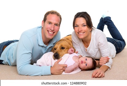 Baby Mother And Father Happy Family With Golden Retriever Dog On Carpet