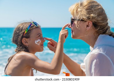 The baby and the mother are putting sunscreen on their face. Selective focus. Kid. - Powered by Shutterstock