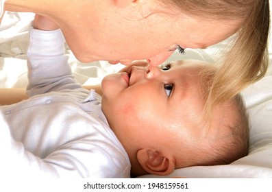 Baby In Mother's Arms And Been Cared For After Having A Good Sleep In Bed Stock Photo