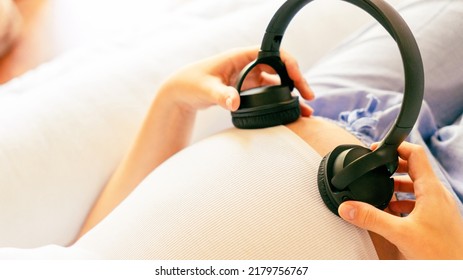 Baby Music Pregnancy Woman. Cheerful Pregnant Girl Relaxing Listening Music In Headphones. Mother Belly Listen Headphones Sound. Therapy, Healthcare, Motherhood Concept