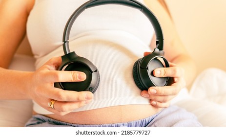 Baby Music Pregnancy Woman. Cheerful Pregnant Girl Relaxing Listening Music In Headphones. Mother Belly Listen Headphones Sound. Therapy, Healthcare, Motherhood Concept