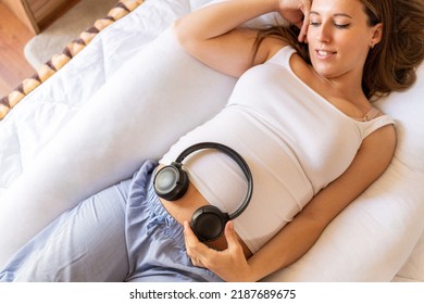 Baby Music Pregnancy Woman. Cheerful Pregnant Girl Relaxing Listening Music In Headphones. Mother Belly Listen Headphones Sound. Therapy, Healthcare, Motherhood Concept