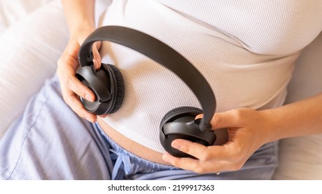 Baby Music Pregnancy Woman. Cheerful Pregnant Girl Relaxing Listening Music In Headphones. Mother Belly Listen Headphones Sound. Therapy, Healthcare, Motherhood Concept