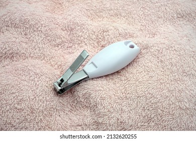 A Baby Nail Clipper On A Pink Towel. Ideal For Graphic Design Background.