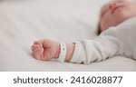 Baby, new born and hand with bracelet on bed for care, trust or support in hospital for birth. Infant, love and hope with child development for future growth in family home, protection and security