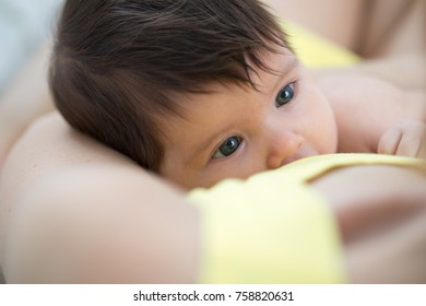 Baby newborn feeds on mother's breasts milk