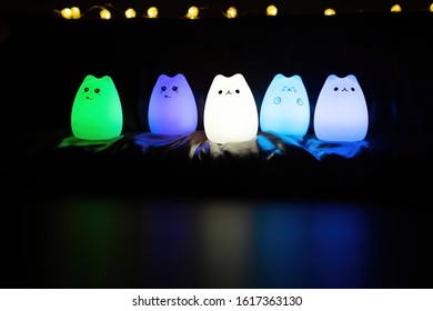 Baby Night Lamp, Five Nightlights In A Row, Different Colors. Children's Night Lights. Night Shooting. Several Lamps On The Couch. Front View.