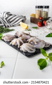 Baby Octopus. Freshly Frozen. Beautiful Serving On A Platter. With Herbs And Spices On A Light Background