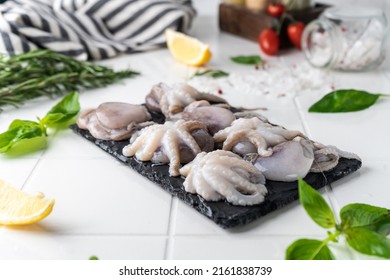 Baby Octopus. Freshly Frozen. Beautiful Serving On A Platter. With Herbs And Spices On A Light Background