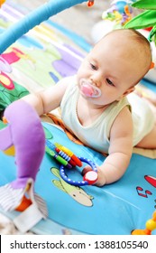 A Baby On The Carpet With Toys