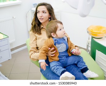 Baby On Mothers Lap At The Dentists Appointment. Children's Dentist.