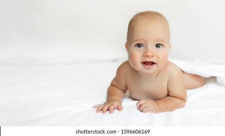 Baby on White background. Adorable two month old baby boy lying on the bad. Concept photo parenthood and motherhood.