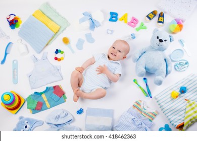 Baby on white background with clothing, toiletries, toys and health care accessories. Wish list or shopping overview for pregnancy and baby shower. View from above. Child feeding, changing and bathing