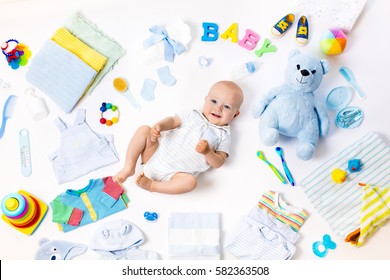 Baby on white background with clothing, toiletries, toys and health care accessories. Wish list or shopping overview for pregnancy and baby shower. View from above. Child feeding changing and bathing