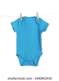 Baby onesie hanging on clothes line against white background. Laundry day