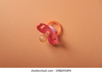 Baby Pacifier On An Orange Background, Top View, Place For An Inscription