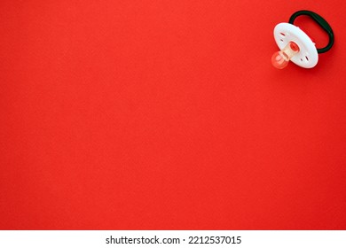 Baby Pacifier On A Red Background With Copy Space. Rubber Pacifier, Top View