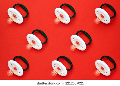 Baby Pacifier On A Red Background, Close-up. Rubber Pacifier Pattern, Top View