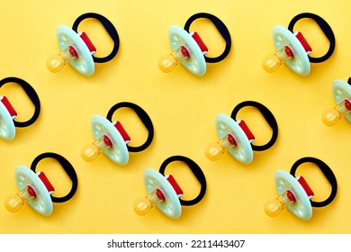 Baby Pacifier On A Yellow Background, Close-up. Rubber Pacifier Pattern, Top View