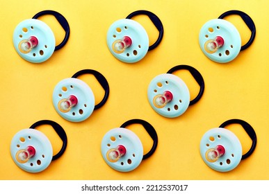 Baby Pacifier On A Yellow Background, Close-up. Rubber Pacifier Pattern, Top View