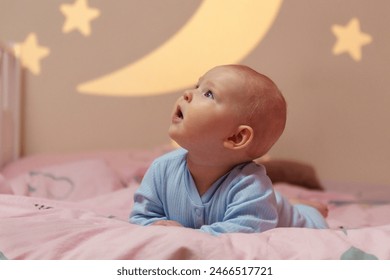 Baby peacefully lays on a bed adorned with a celestial theme featuring a moon and stars, creating a serene and enchanting atmosphere. - Powered by Shutterstock