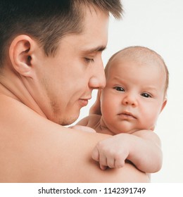 baby peeking out from behind dad's shoulder on white background. Man and child