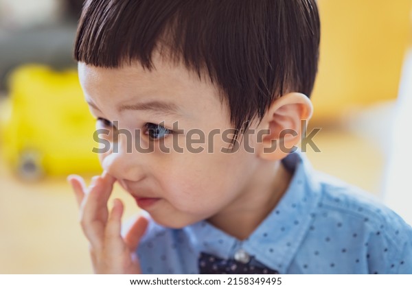 baby picking nose. little baby boy with finger in\
his nose. Cute little baby boy picking his nose, close up.\
children\'s behavior. Selective\
Focus.