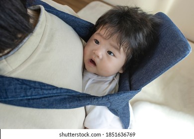 Baby piggybacked with a piggyback strap, 0 years old, 4 months old, baby - Powered by Shutterstock