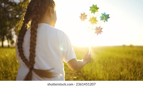 baby pinwheel. little girl silhouette plays with windmill a toy wind in park. happy family childhood dream concept. girl play fun spinner toy glare of the sun at sunset in cheerful park - Powered by Shutterstock