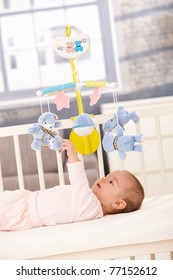 Baby Playing With Bed Mobile Toy, Reaching Up To Teddy Bear.?