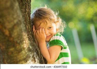 baby is playing hide-and-seek hiding face