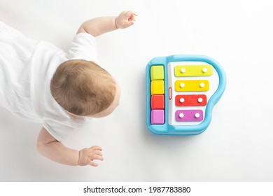 Baby Playing With A Baby Piano, On A White Background