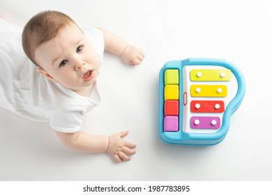 Baby Playing With A Baby Piano, On A White Background