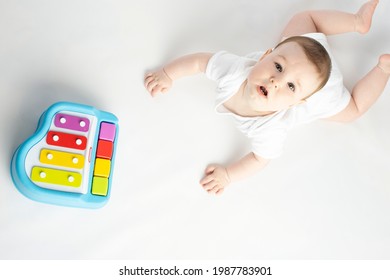 Baby Playing With A Baby Piano, On A White Background