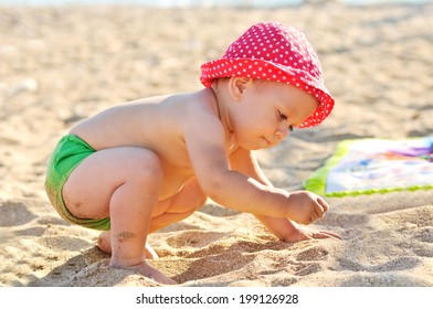 Baby Playing With Sand On The Beach 